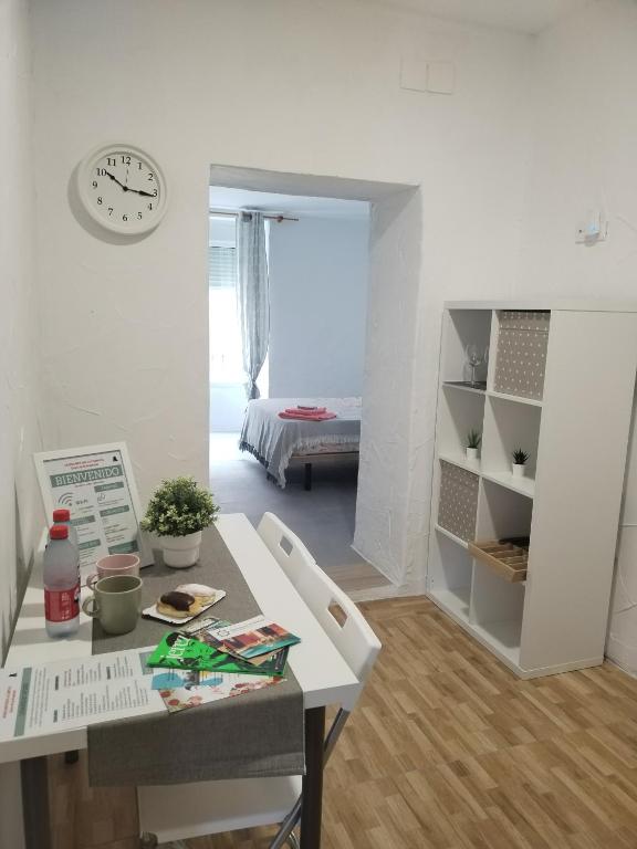 a room with a table and a clock on the wall at Apartamentos La Campana 1 in Jerez de la Frontera
