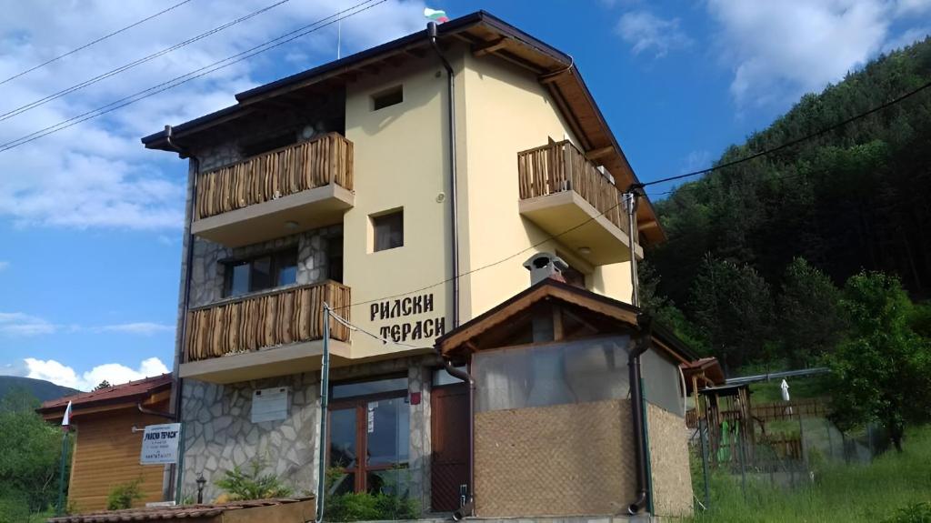 a building with a sign on the side of it at Mini Complex Rilski Terasi in Sapareva Banya