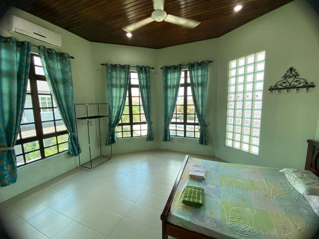 Cette grande chambre comprend un lit et des fenêtres. dans l'établissement Sri Panorama Home, à Kota Bharu