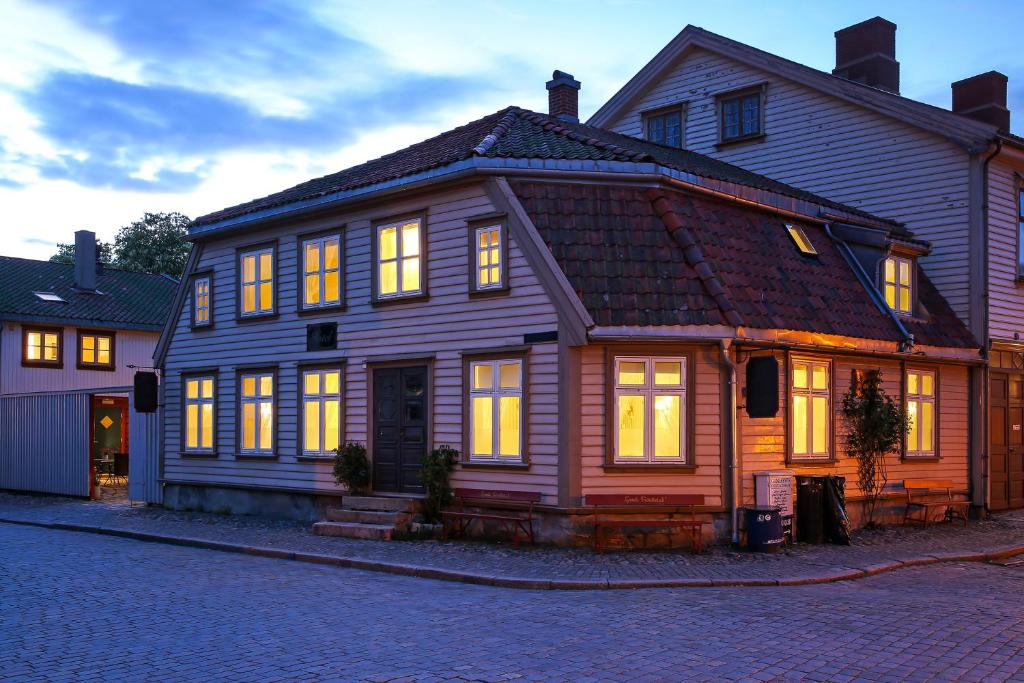 una gran casa de madera con luces encendidas en Gamlebyen Hotell - Fredrikstad en Fredrikstad