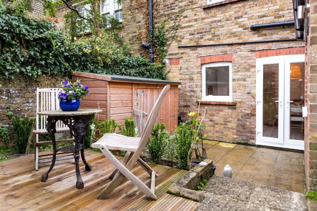 a chair and a table on a wooden deck at South Downs Garden Cottage in Old Town