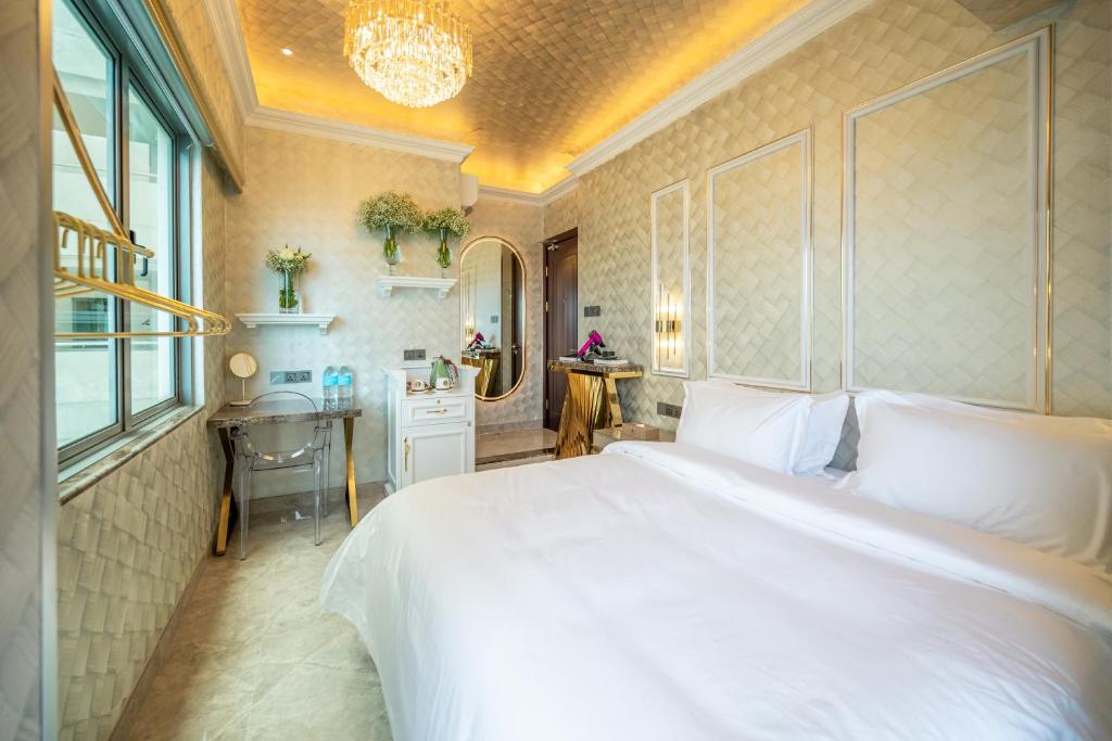a bedroom with a large white bed and a desk at Ritz Residence @ Imago Loft B 7th Floor in Kota Kinabalu