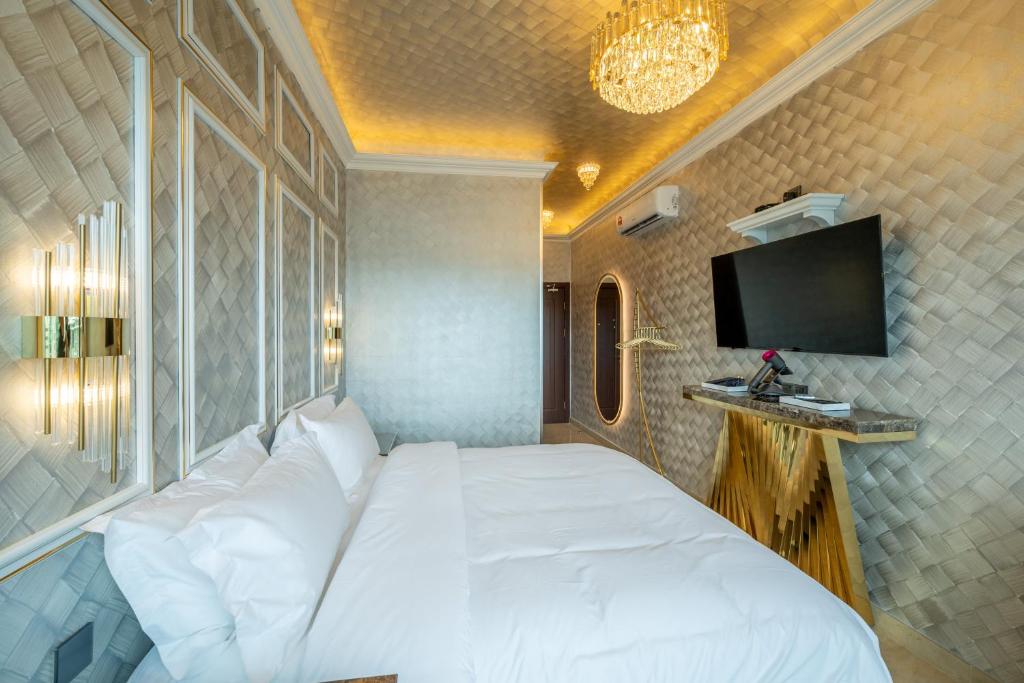 a bedroom with a white bed and a tv at Ritz Residence @ Imago Loft B 7th Floor in Kota Kinabalu
