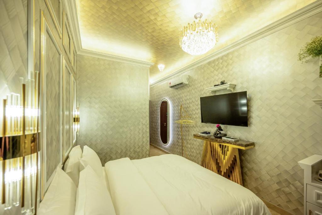 a bedroom with a white bed and a tv at Ritz Residence @ Imago Loft B 7th Floor in Kota Kinabalu