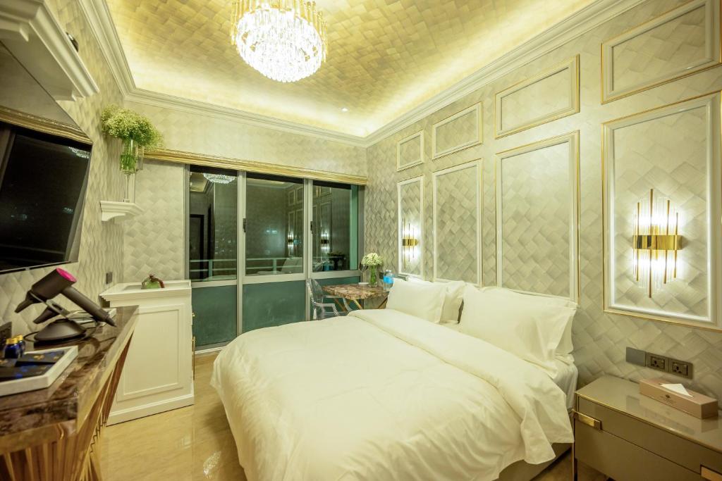 a bedroom with a large white bed and a chandelier at Ritz Residence @ Imago Loft B 7th Floor in Kota Kinabalu