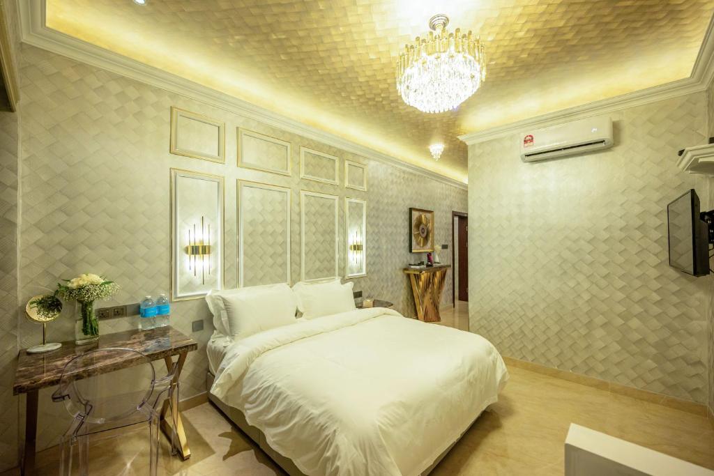 um quarto com uma grande cama branca e um lustre em Ritz Residence @ Imago Loft B 7th Floor em Kota Kinabalu