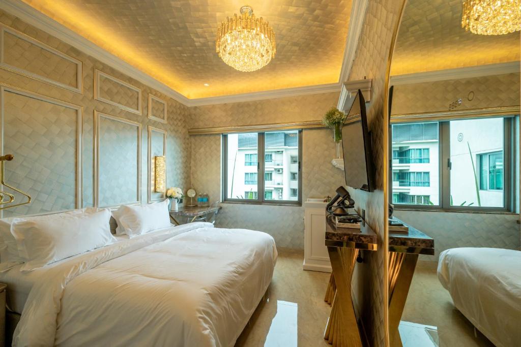 a bedroom with a bed and a desk and windows at Ritz Residence @ Imago Loft B 7th Floor in Kota Kinabalu