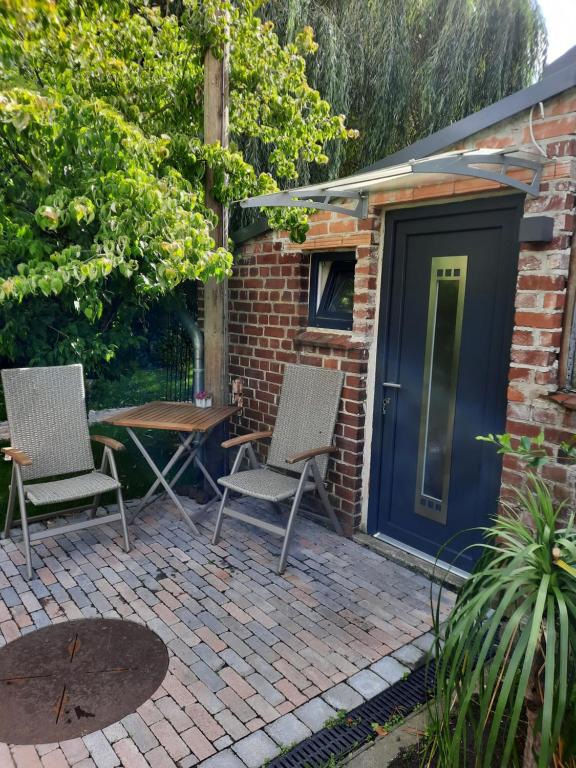 a patio with two chairs and a blue door at Studio Mini-Mexiko in Arnsberg