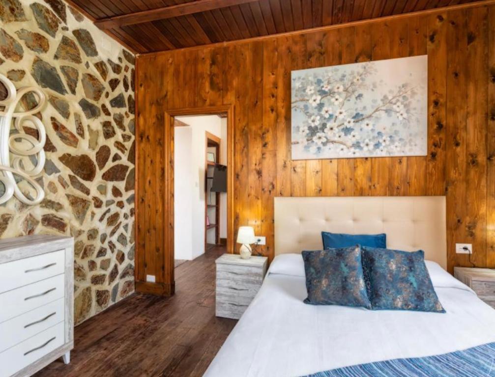 Un dormitorio con una pared de piedra y una cama en LAS VALKIRIAS, en El Paso