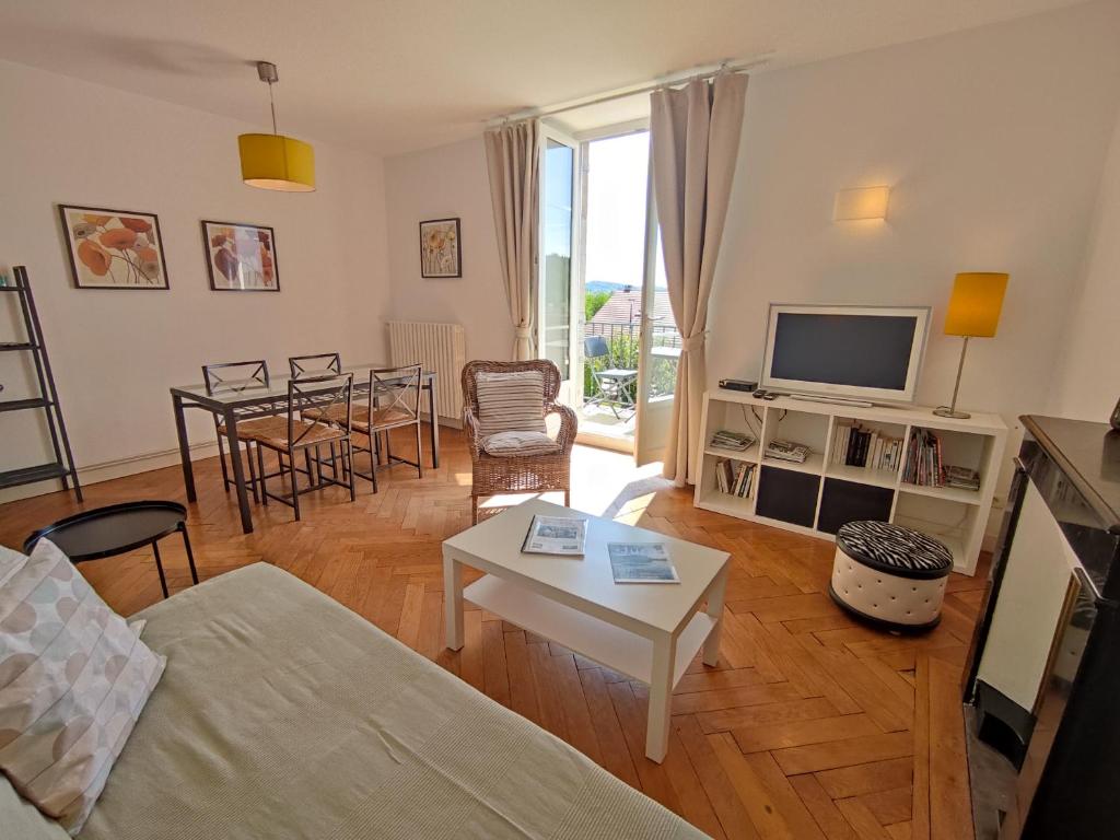 a living room with a couch and a table at VILLAS-DU-LAC Appartements de vacances et Espace Spa privé in Clairvaux-les-Lacs