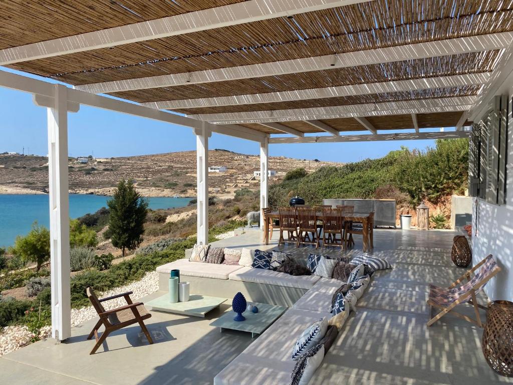d'une terrasse avec bancs et tables et vue sur l'eau. dans l'établissement Villa Baldin, à Lipsi
