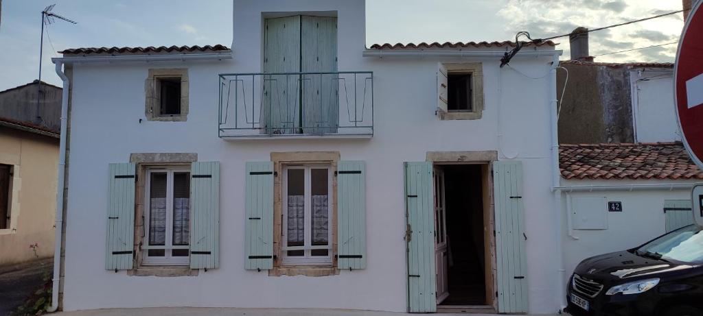 a white building with windows and a balcony at Maison 6 personnes animaux acceptés in Marennes