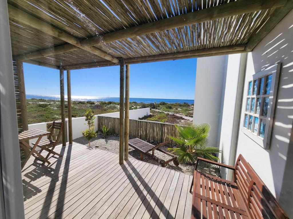 a porch with benches and a view of the ocean at Mirage-Beach Apartment in St Helena Bay