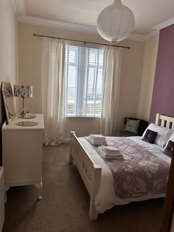1 dormitorio con cama, escritorio y ventana en Castle Brae Apartment en Stirling