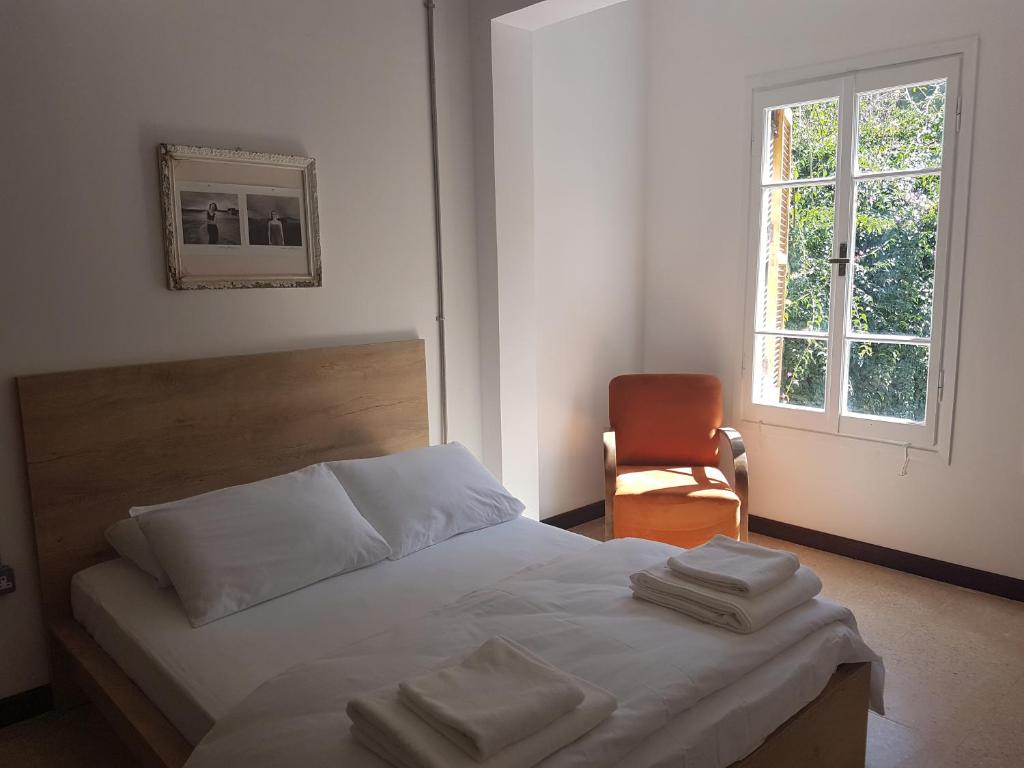 a bedroom with a bed and a chair and a window at Sabor Residence in North Nicosia