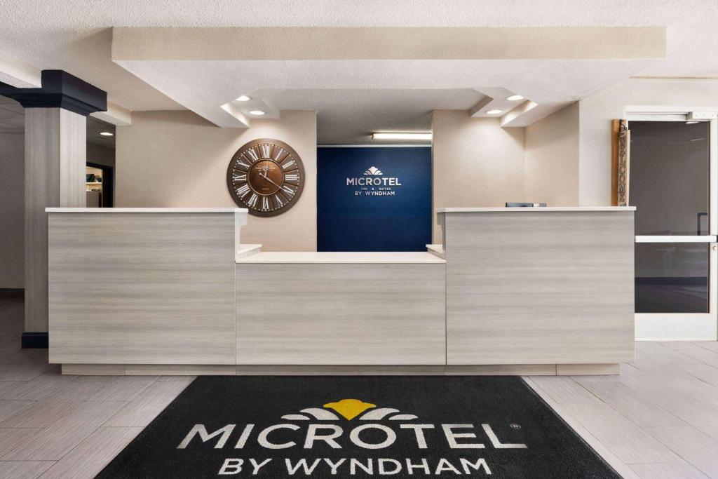 eine Lobby mit einer großen Uhr an der Wand in der Unterkunft Microtel Inn & Suites by Wyndham Florence/Cincinnati Airpo in Florence
