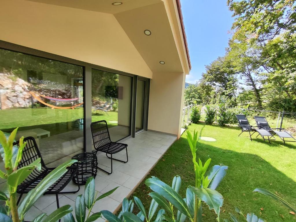 Gaja & Sara Apartments في كوزينا: شاشة في الشرفة مع الكراسي والحديقة