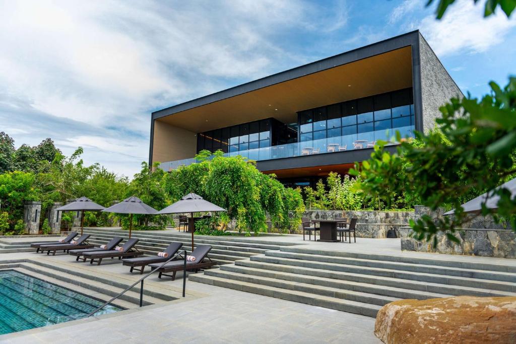雅拉的住宿－Hilton Yala Resort，一座带游泳池、椅子和遮阳伞的建筑