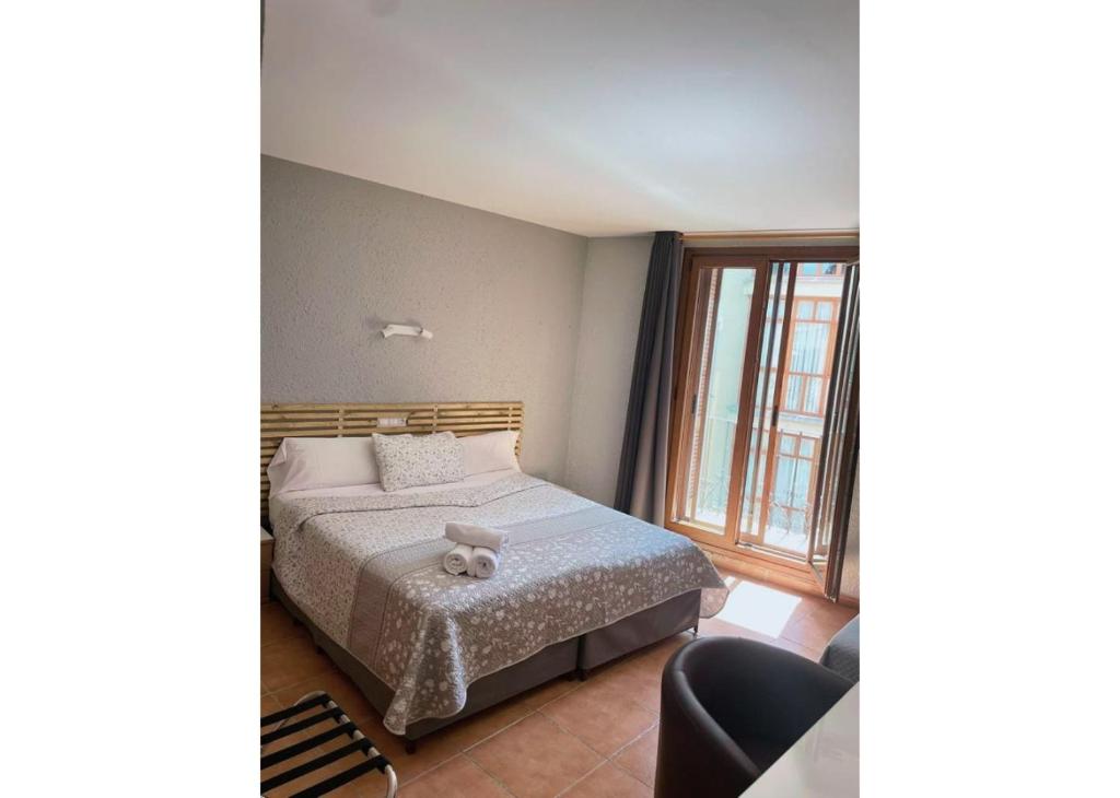 Un dormitorio con una cama con un osito de peluche. en Hotel Acebo Plaza Mayor en Jaca