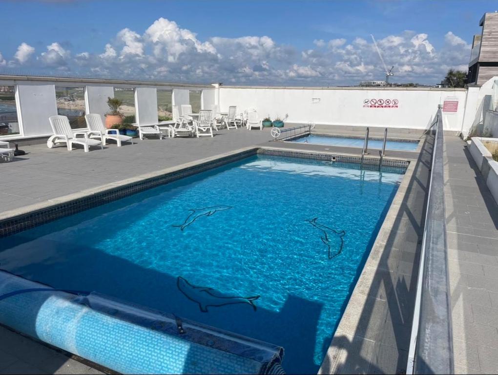 a swimming pool with dolphins painted on the side of a building at Newquay Fistral Beach View in Newquay