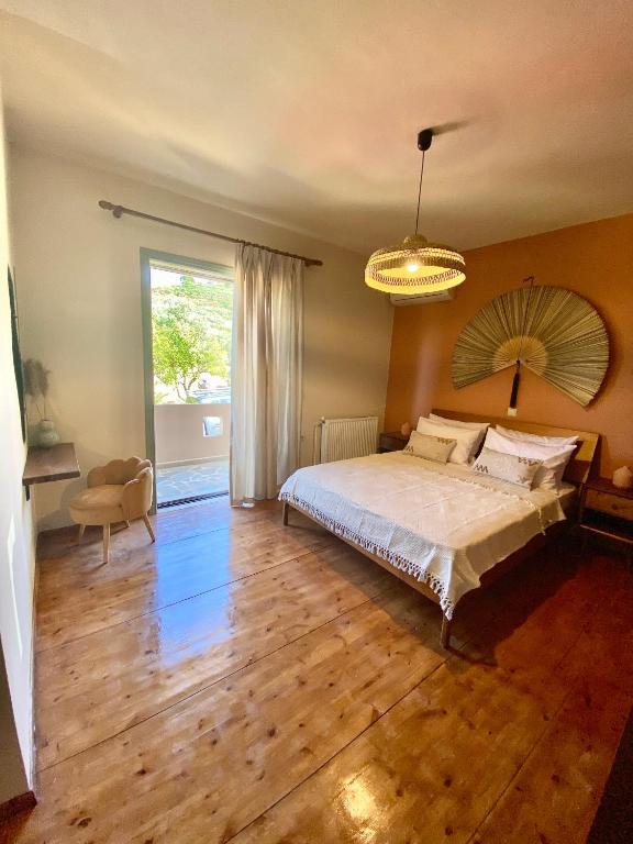 um quarto com uma cama e uma grande janela em The Leaf House em Varípetron