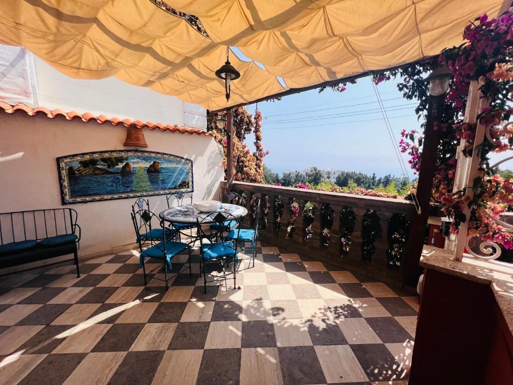 a balcony with a table and chairs and a window at LUXURY House in VILLA POMPEIANA Via Camerelle con Terrazza Vista Mare in Capri