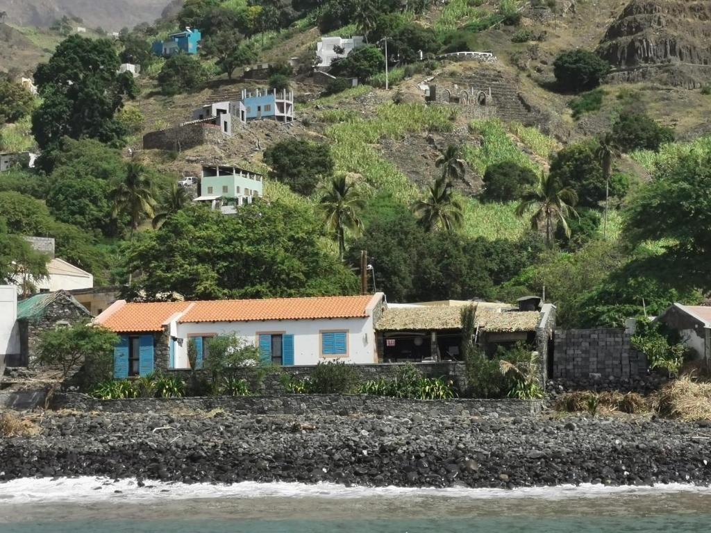 a house on a hill next to the water at Casa Praia Tarrafal de Monte Trigo in Seladinha