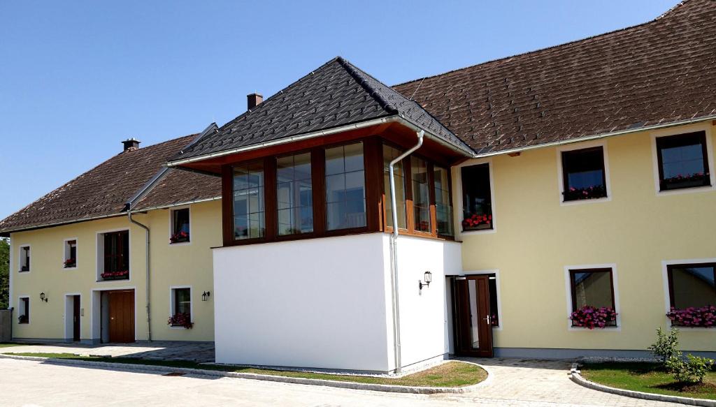 una gran casa blanca con garaje blanco en Gästehaus Watschinger, en Bad Wimsbach-Neydharting