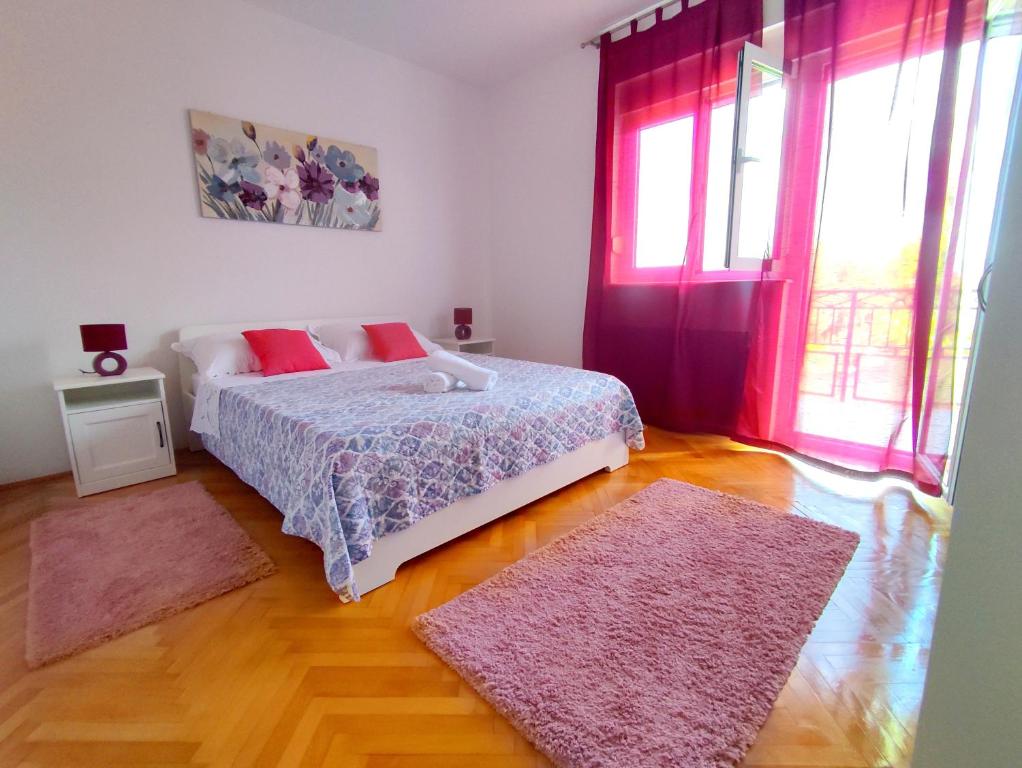 a bedroom with a bed and two rugs at Apartment Tea 1 in Okrug Donji