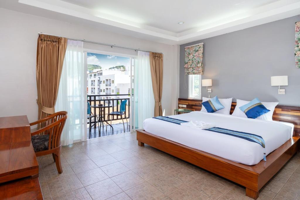 Un dormitorio con una cama grande y un balcón. en SawasdeeCiao Patong Guesthouse, en Patong Beach