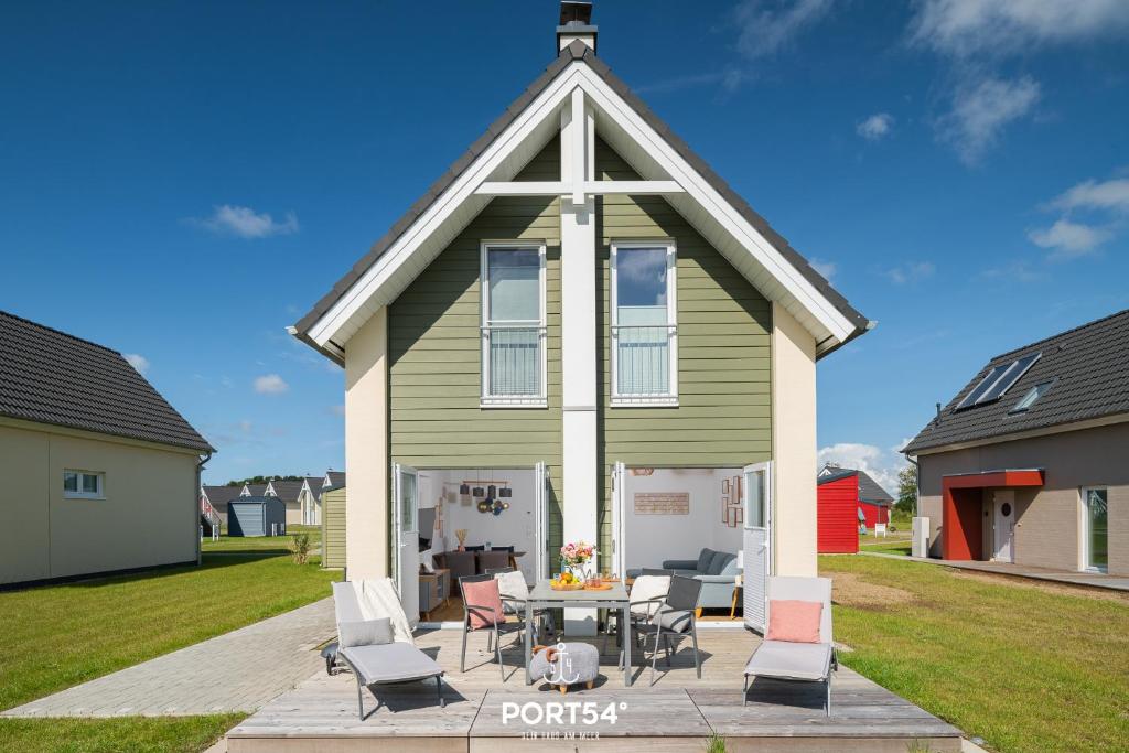 a house with a table and chairs in front of it at Nordic Lodge in Büsum