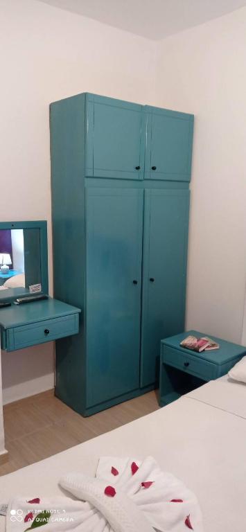 een slaapkamer met een bed met een blauwe kast en een bureau bij Şahin Otel in Bodrum City