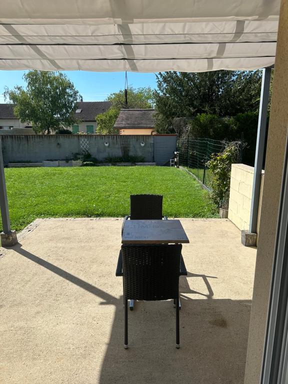 een tafel en een stoel op een patio bij Chez Greg et Laëtitia2 