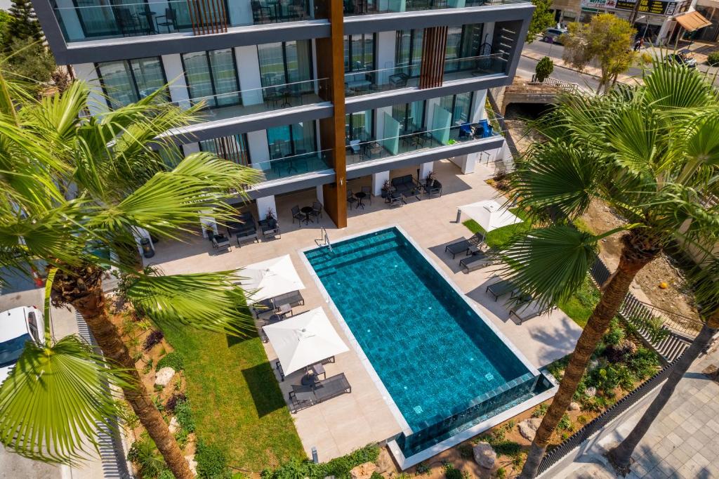 an aerial view of a hotel with a swimming pool and palm trees at Waterside Sea View Apartments in Paphos City