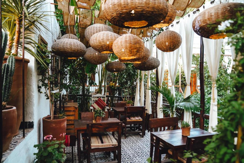 a room filled with lots of potted plants and lamps at La Ferme Medina in Marrakech