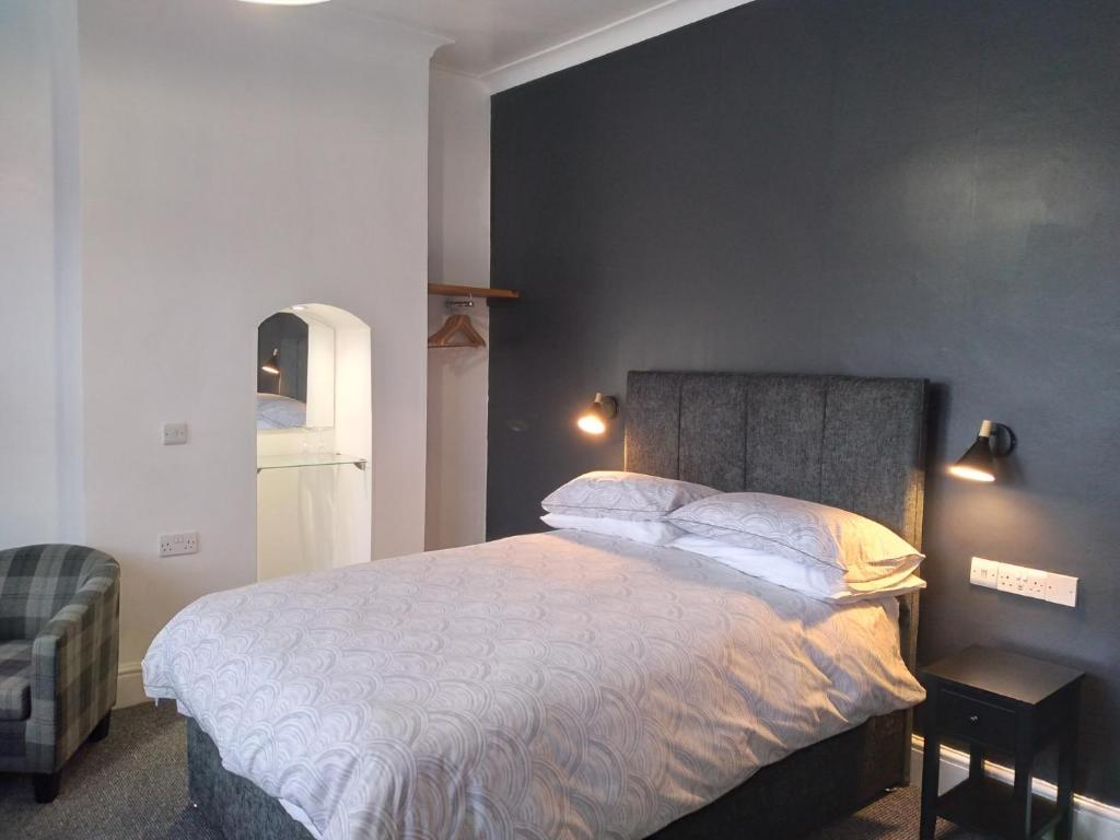 a bedroom with a large bed and a black wall at Wentvale in Knottingly