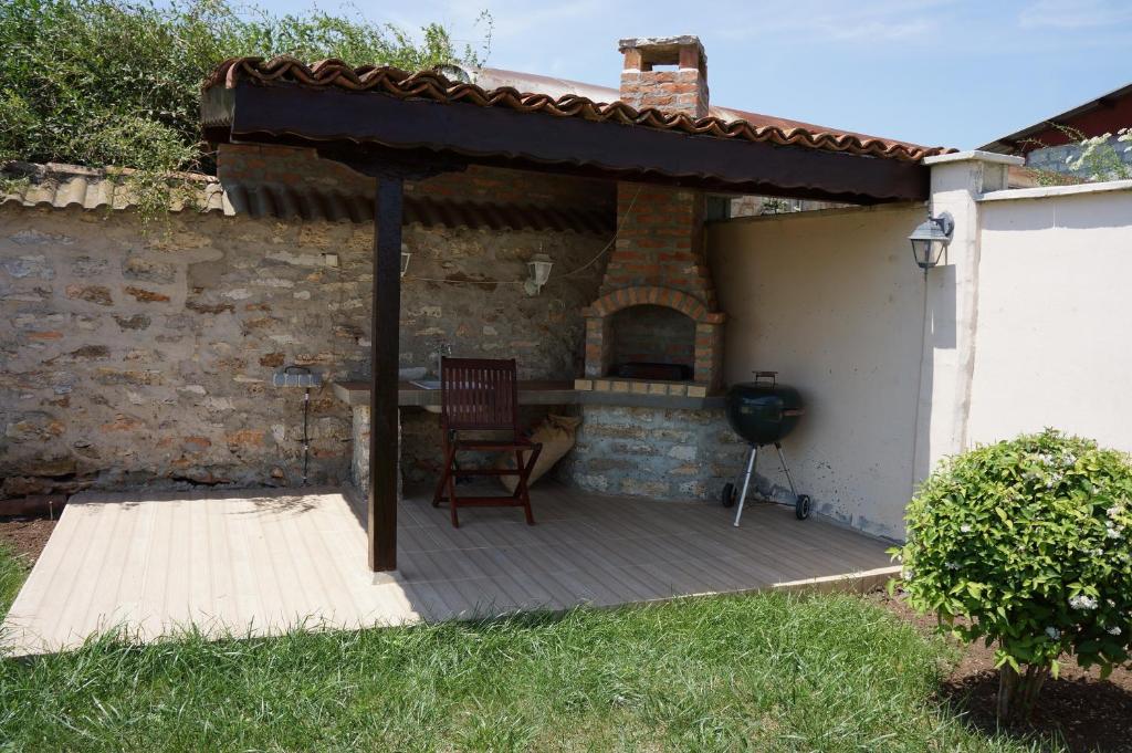 a patio with a fireplace and a chair on a deck at Guest House Golden Flake 4km from Bolata beach in Bŭlgarevo