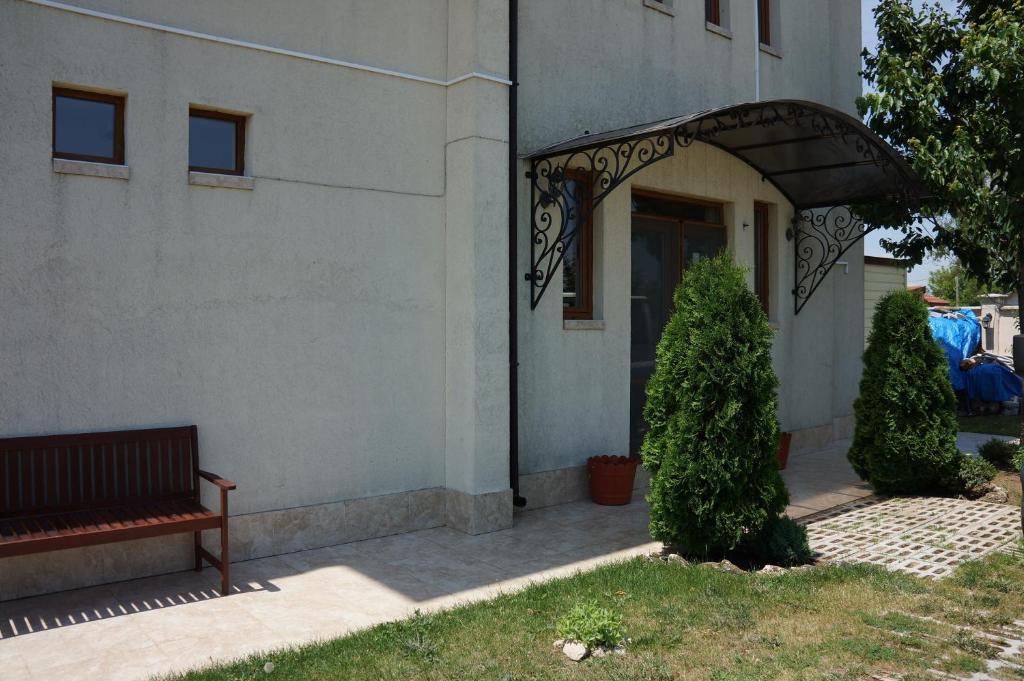 a building with a bench in front of a door at Guest House Golden Flake 4km from Bolata beach in Bŭlgarevo