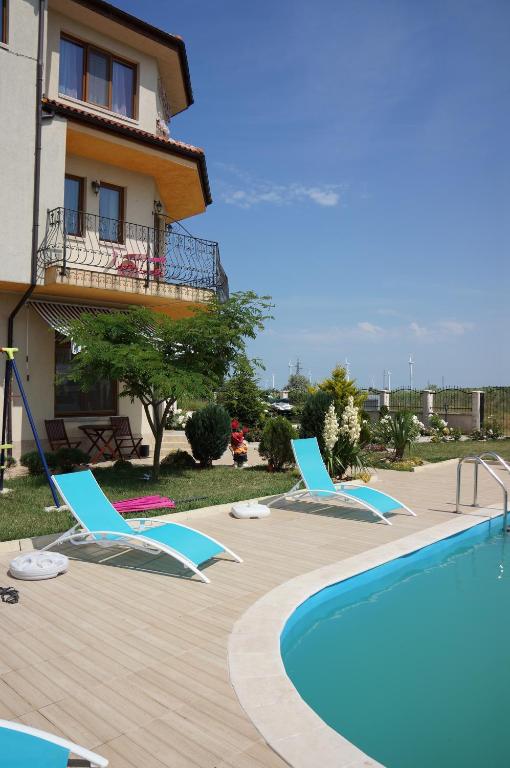 a resort with a swimming pool and chairs and a building at Guest House Golden Flake 4km from Bolata beach in Bŭlgarevo