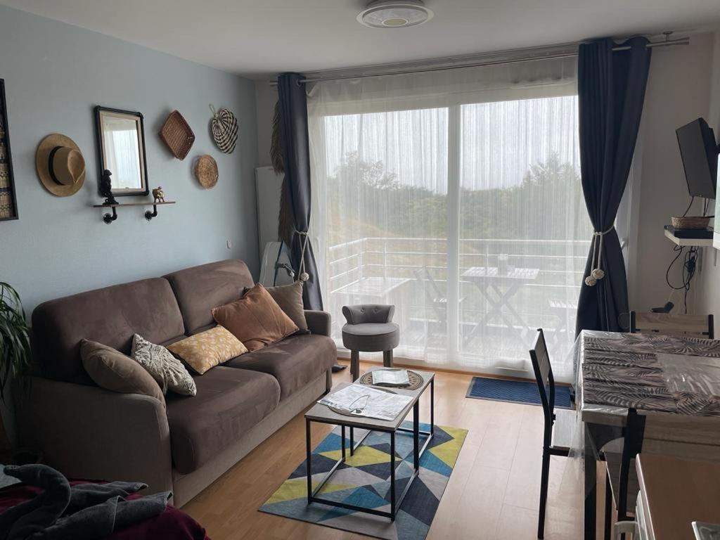 uma sala de estar com um sofá e uma mesa em Les pieds dans le sable em Malo-les-Bains