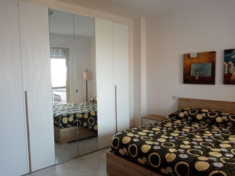 een slaapkamer met een bed en een spiegelkast bij Domo Ilde in Oristano