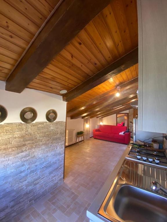 un soggiorno con divano rosso e una cucina di Tulipipì a Sant'Albino