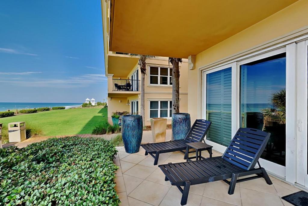 two chairs sitting on a patio in front of a house at Adagio 105B in Santa Rosa Beach