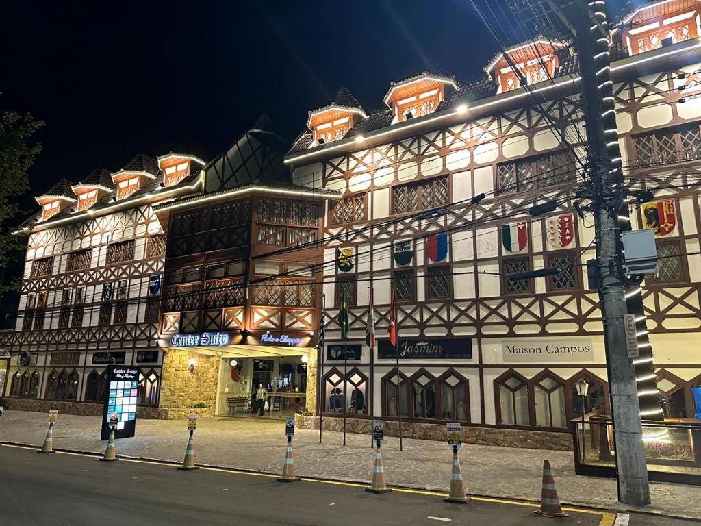 un gran edificio en una calle de la ciudad por la noche en Center Suiço Flats, en Campos do Jordão