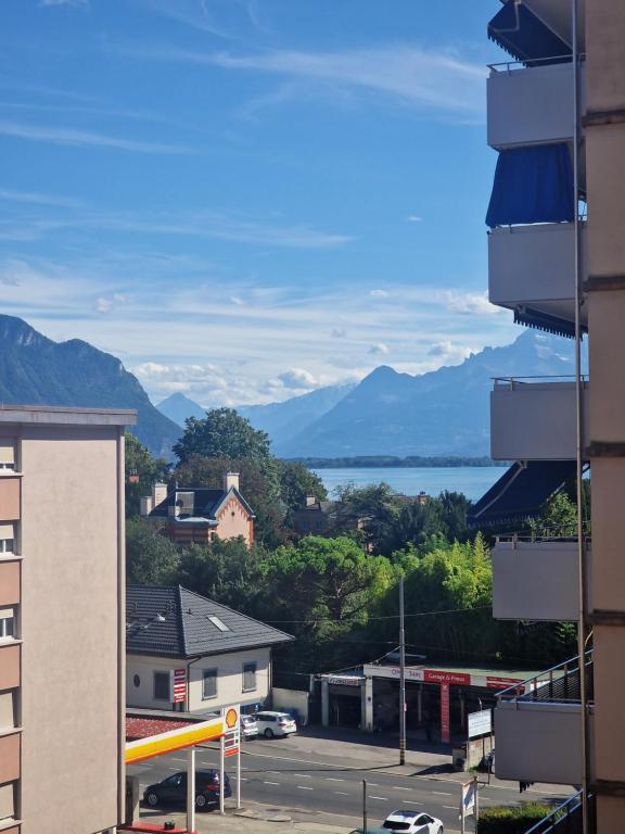 a view of the mountains and water from a building at Grand appartement 4-8 personnes in Montreux