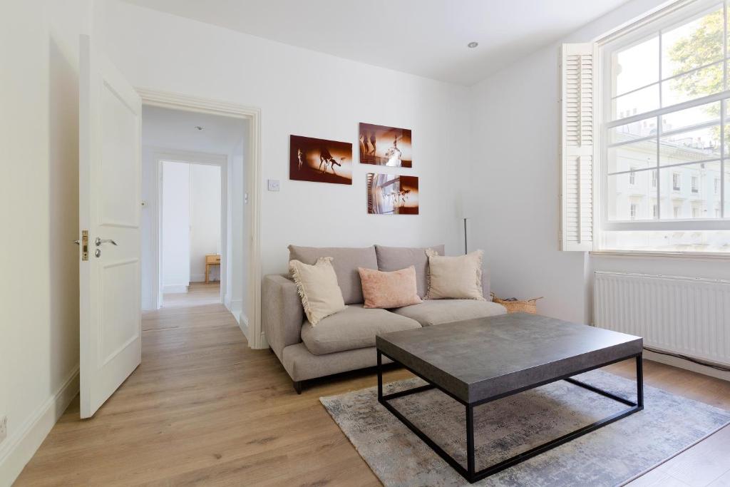 een woonkamer met een bank en een tafel bij Cozy and bright 1 bedroom apt in Knightsbridge in Londen