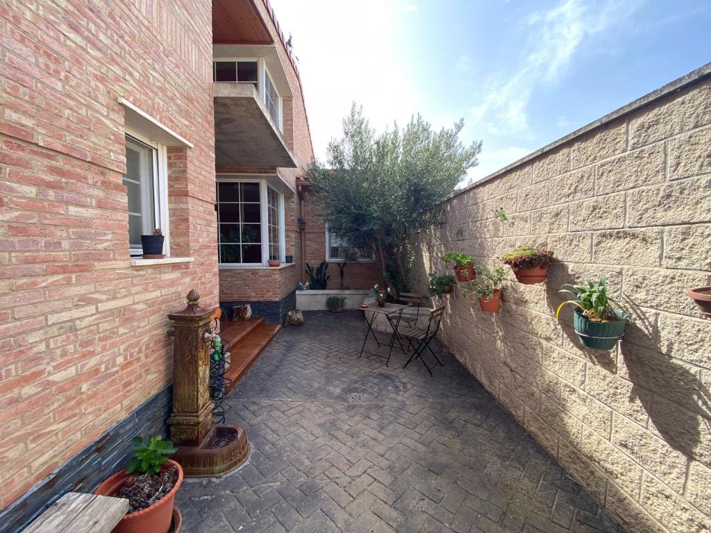 a courtyard of a brick building with potted plants at Casa Rural Goñi in Cabañas de Ebro