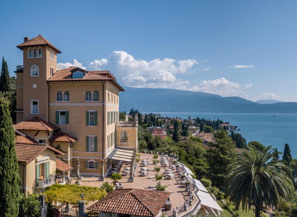 a large building on a hill next to the ocean at Hotel Villa Del Sogno in Gardone Riviera