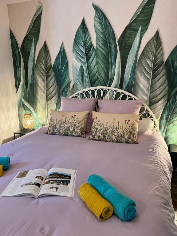 Una cama con dos libros y dos almohadas. en Appartement entre village et plages., en Saint-Cyr-sur-Mer