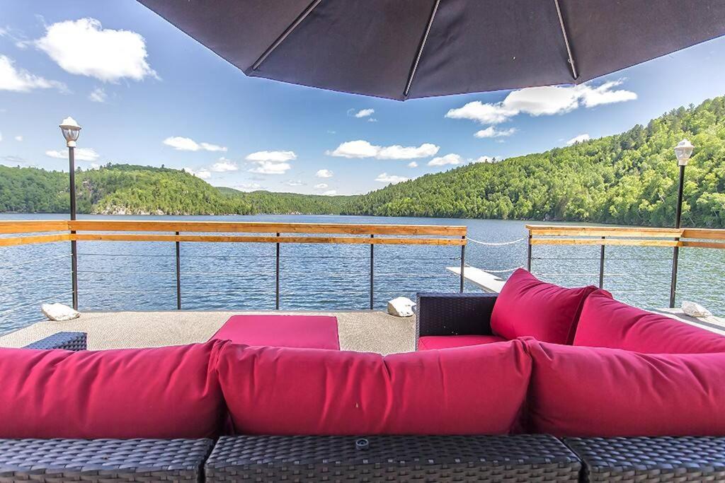 a large red couch sitting on the deck of a boat at Nordika Lac St Pierre No. PERMIS CITQ: 298304 in Val des Monts